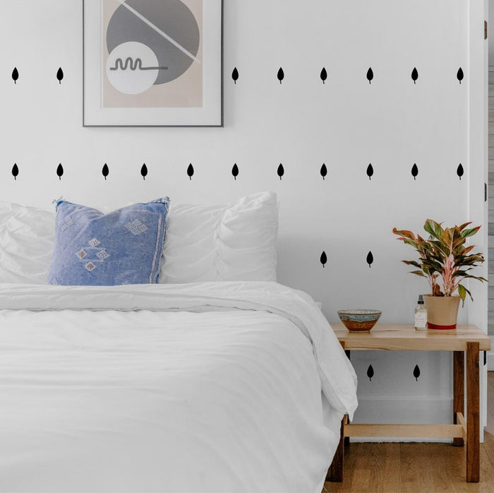 Leaf wall stickers displayed above a bed