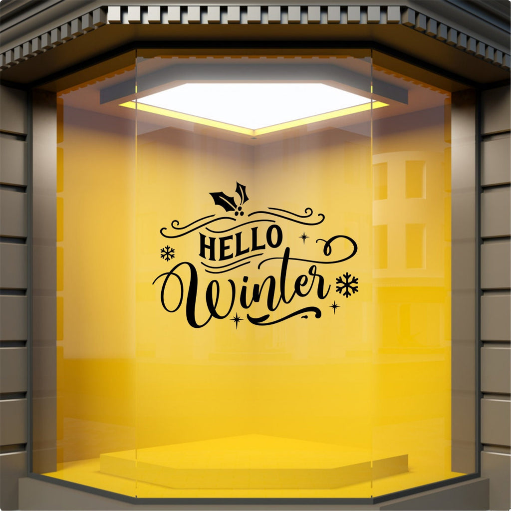 Black Hello Winter vinyl window decal displayed on a yellow shop window