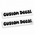 Two matching black custom text vinyl decals in rounded bubble lettering with cut-out details on backing sheets against white.