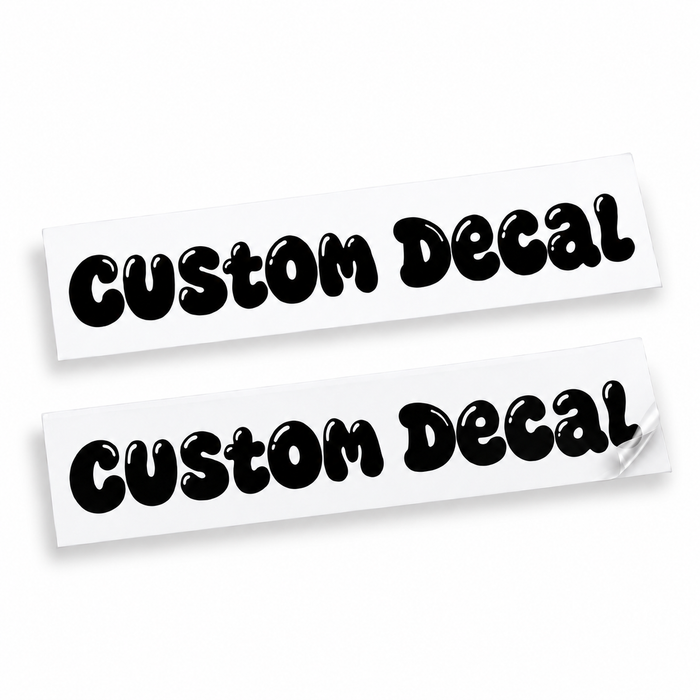 Two matching black custom text vinyl decals in rounded bubble lettering with cut-out details on backing sheets against white.