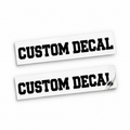 Two matching black Custom Decal vinyl stickers in varsity block lettering on backing sheets against white.