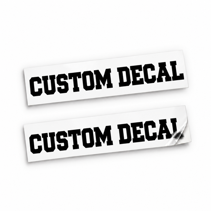 Two matching black Custom Decal vinyl stickers in varsity block lettering on backing sheets against white.
