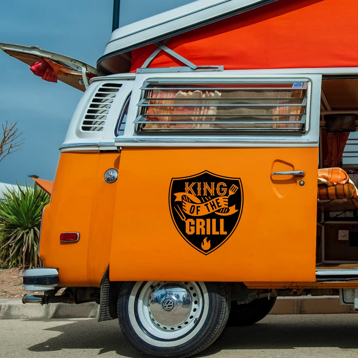 King Of The Grill caravan sticker shown on an orange campervan