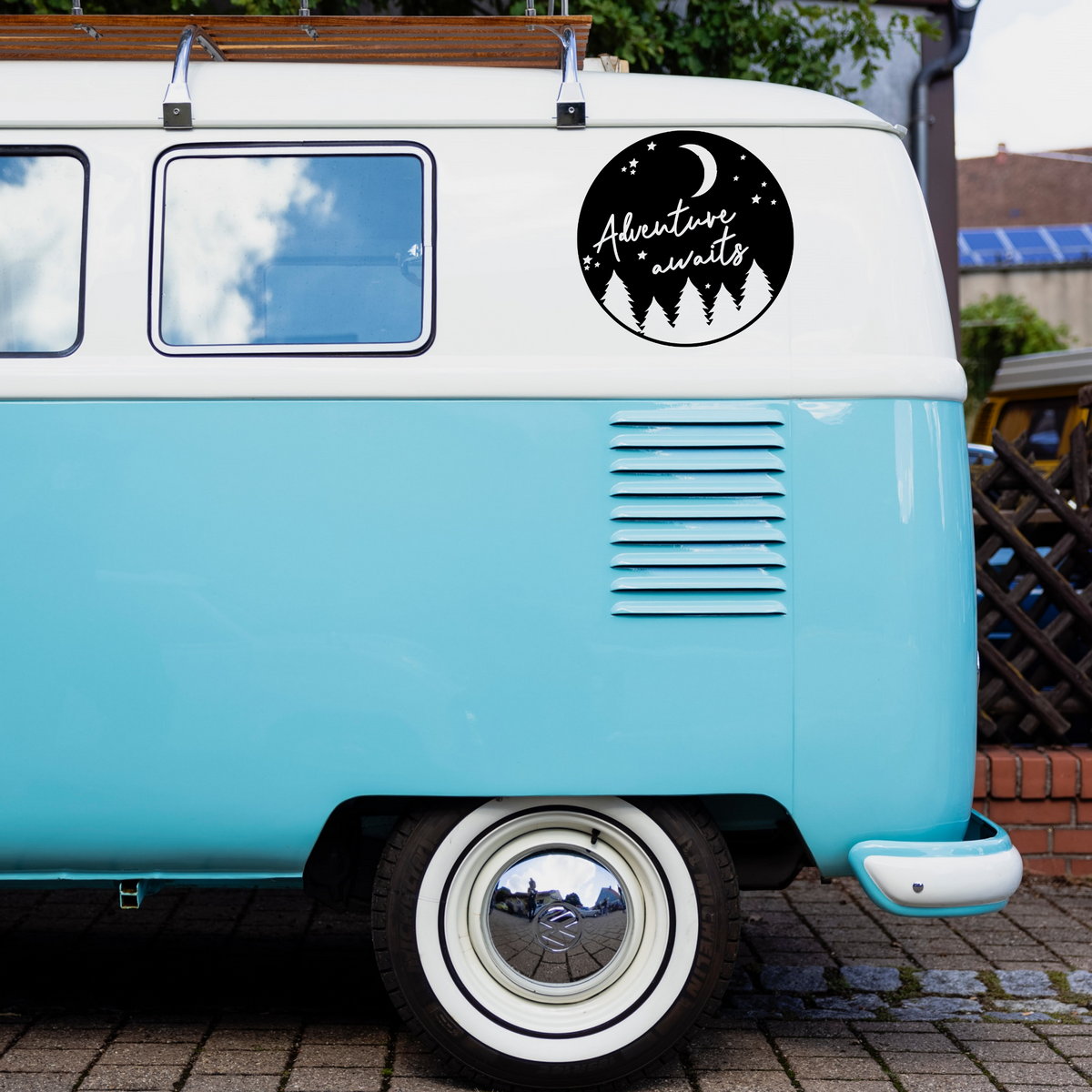 Adventure Awaits caravan sticker shown on a blue campervan
