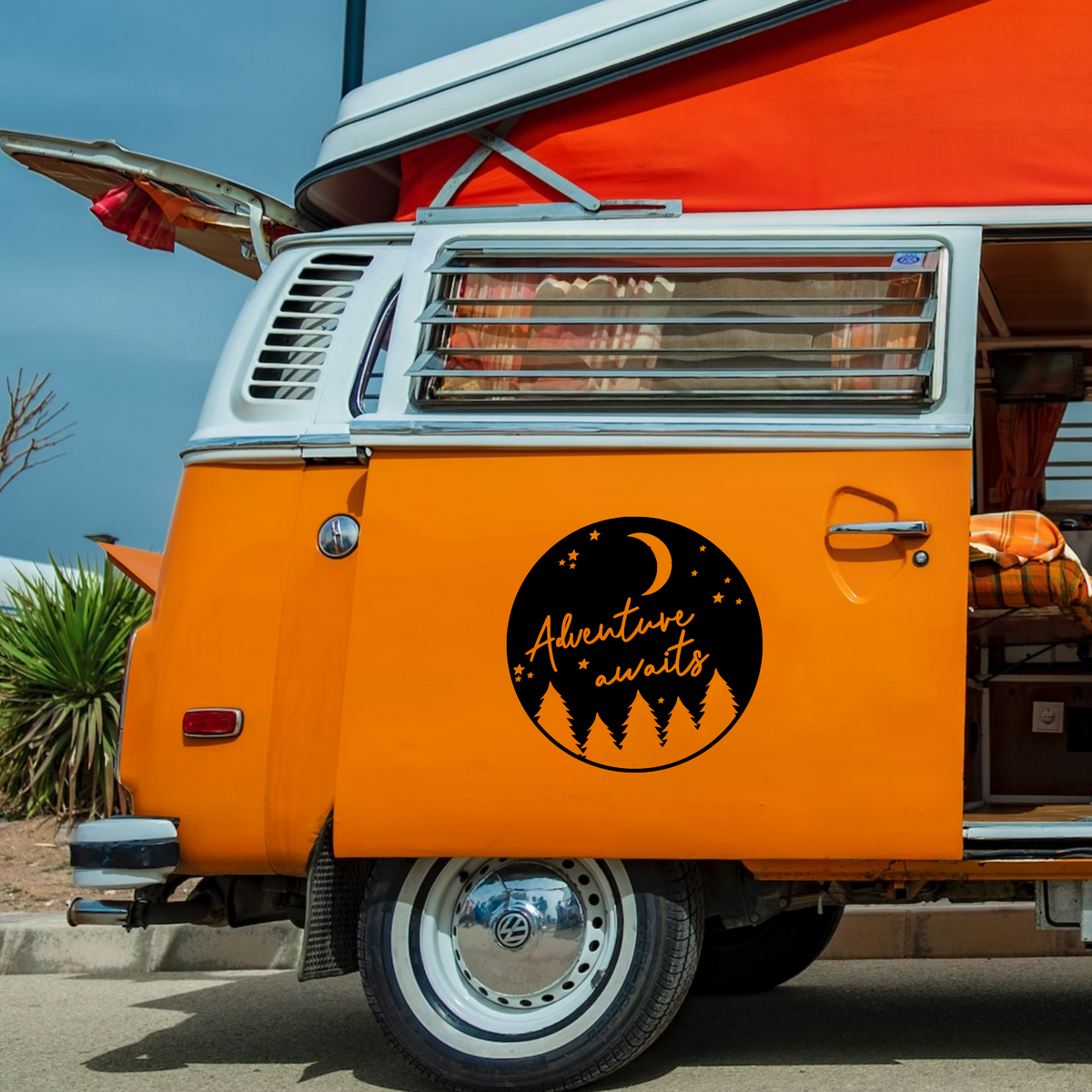 Adventure Awaits caravan sticker shown on an orange campervan