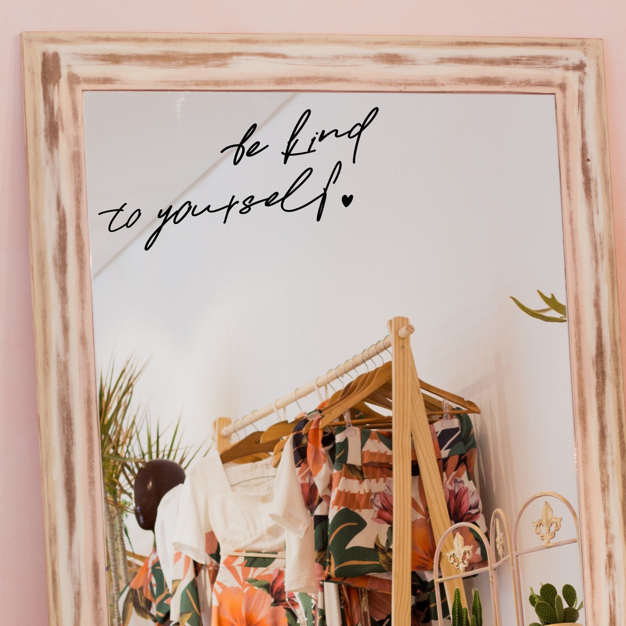 Black “Be Kind To Yourself” vinyl sticker on a framed dressing-room mirror