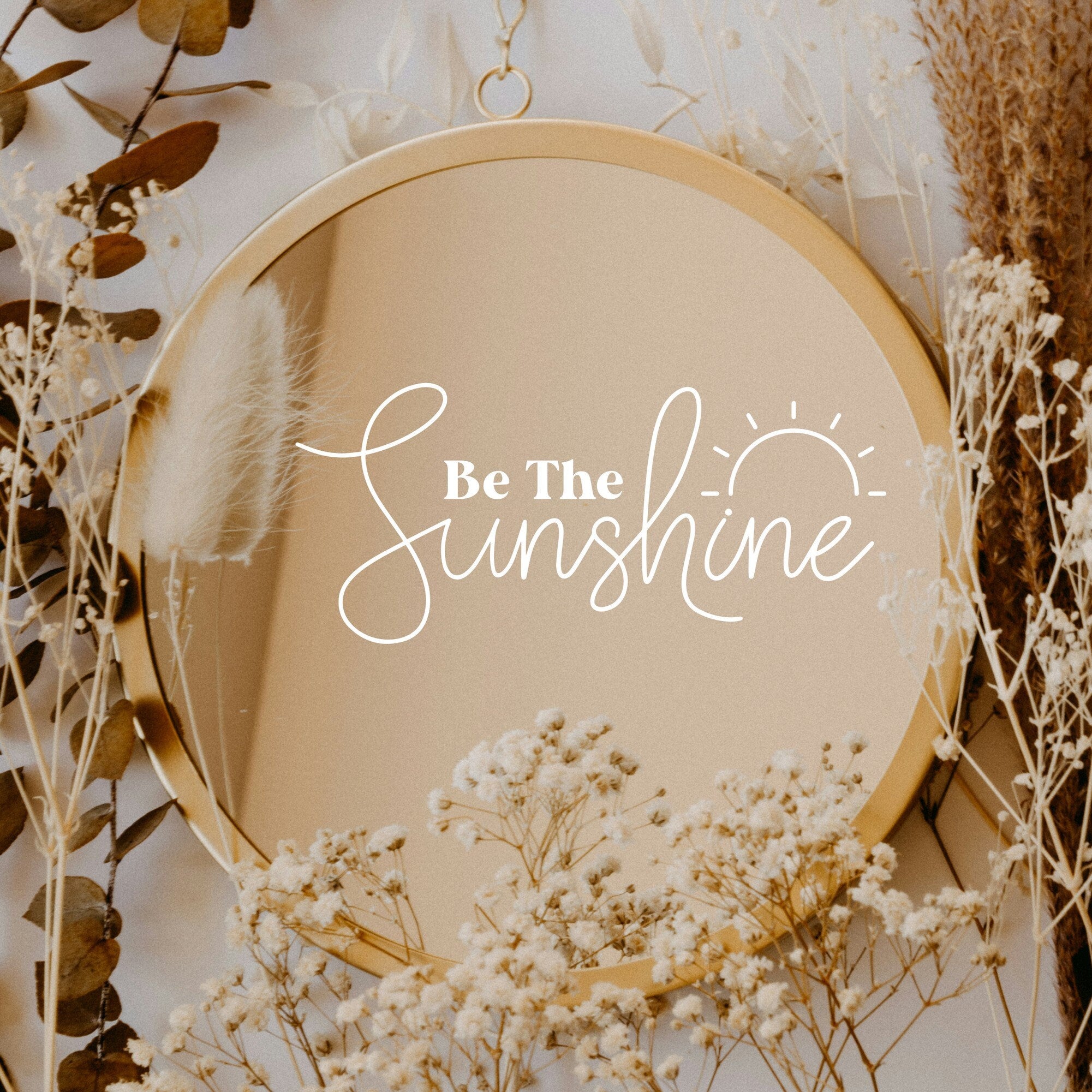 White “Be The Sunshine” vinyl sticker on a round mirror with dried flowers