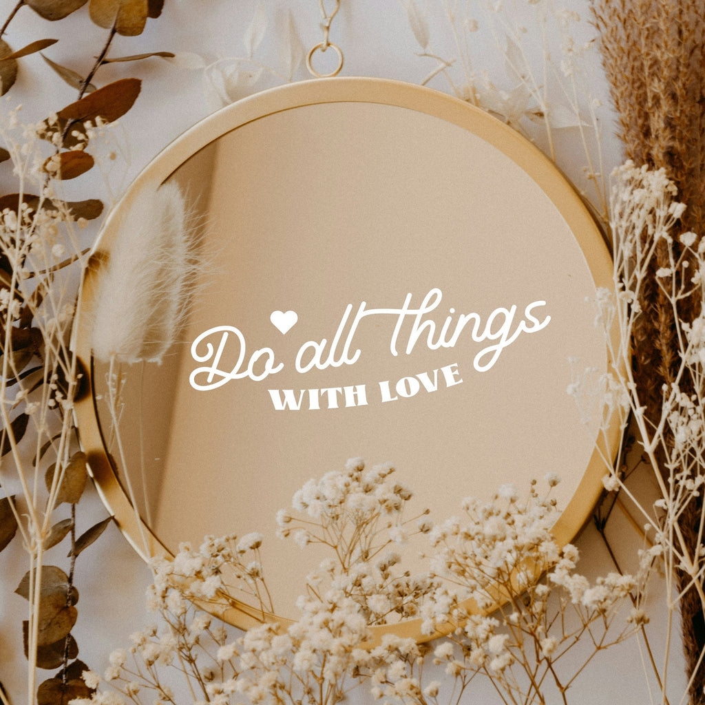 White “Do All Things With Love” vinyl sticker on a round mirror with dried flowers