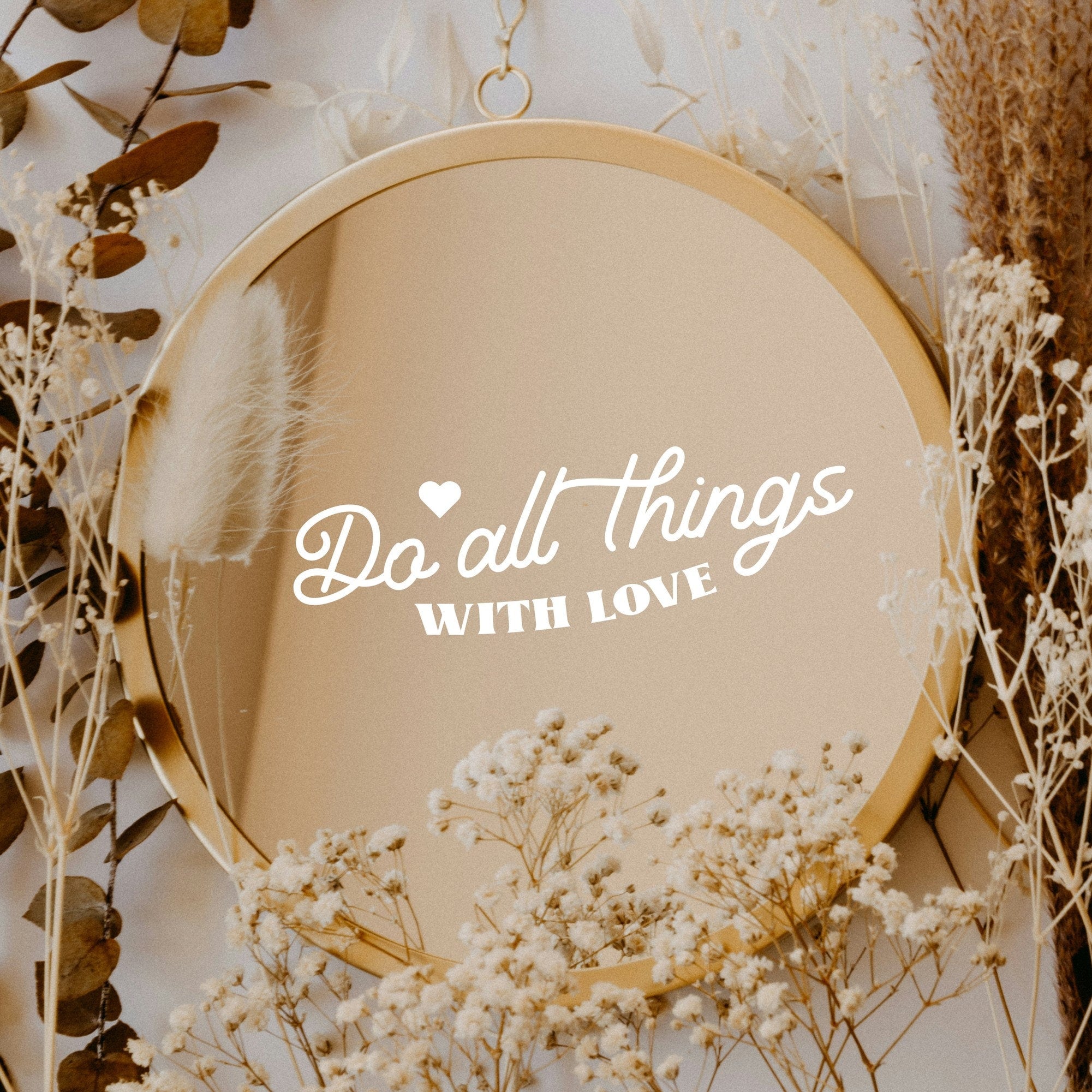 White “Do All Things With Love” vinyl sticker on a round mirror with dried flowers