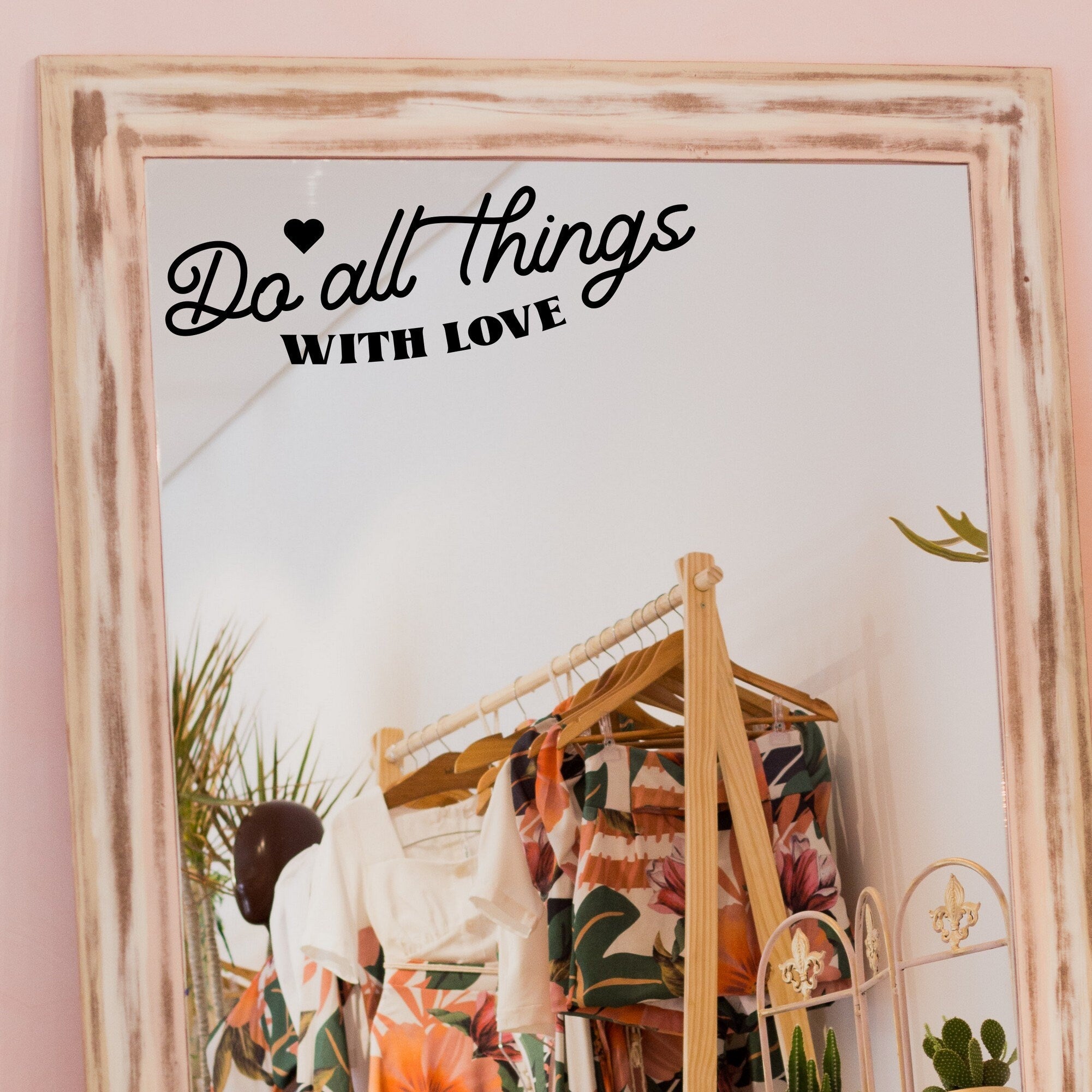 Black “Do All Things With Love” vinyl sticker on a framed dressing-room mirror