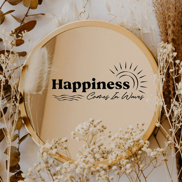 Black “Happiness Comes In Waves” vinyl sticker on a round mirror with dried flowers