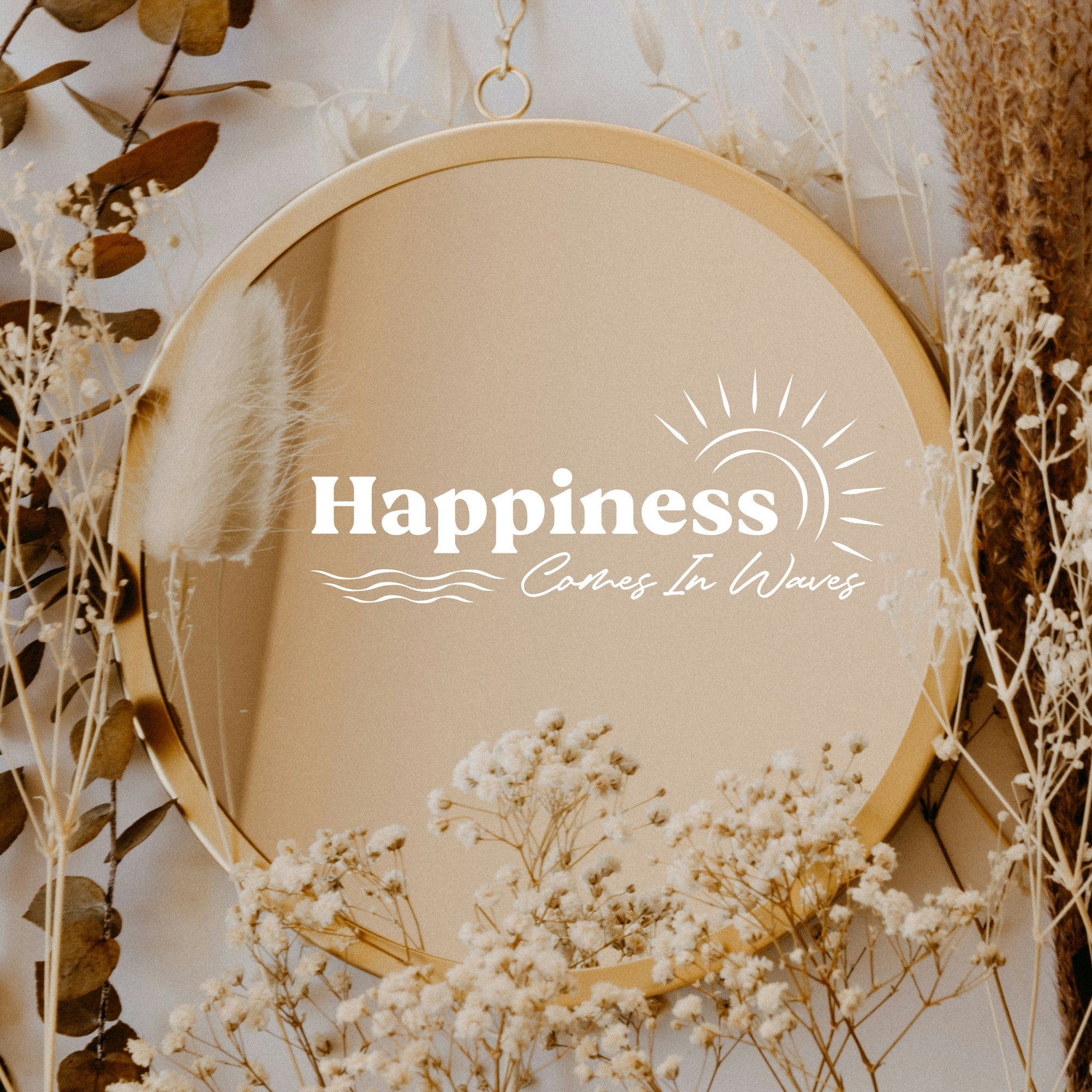 White “Happiness Comes In Waves” vinyl sticker on a round mirror with dried flowers