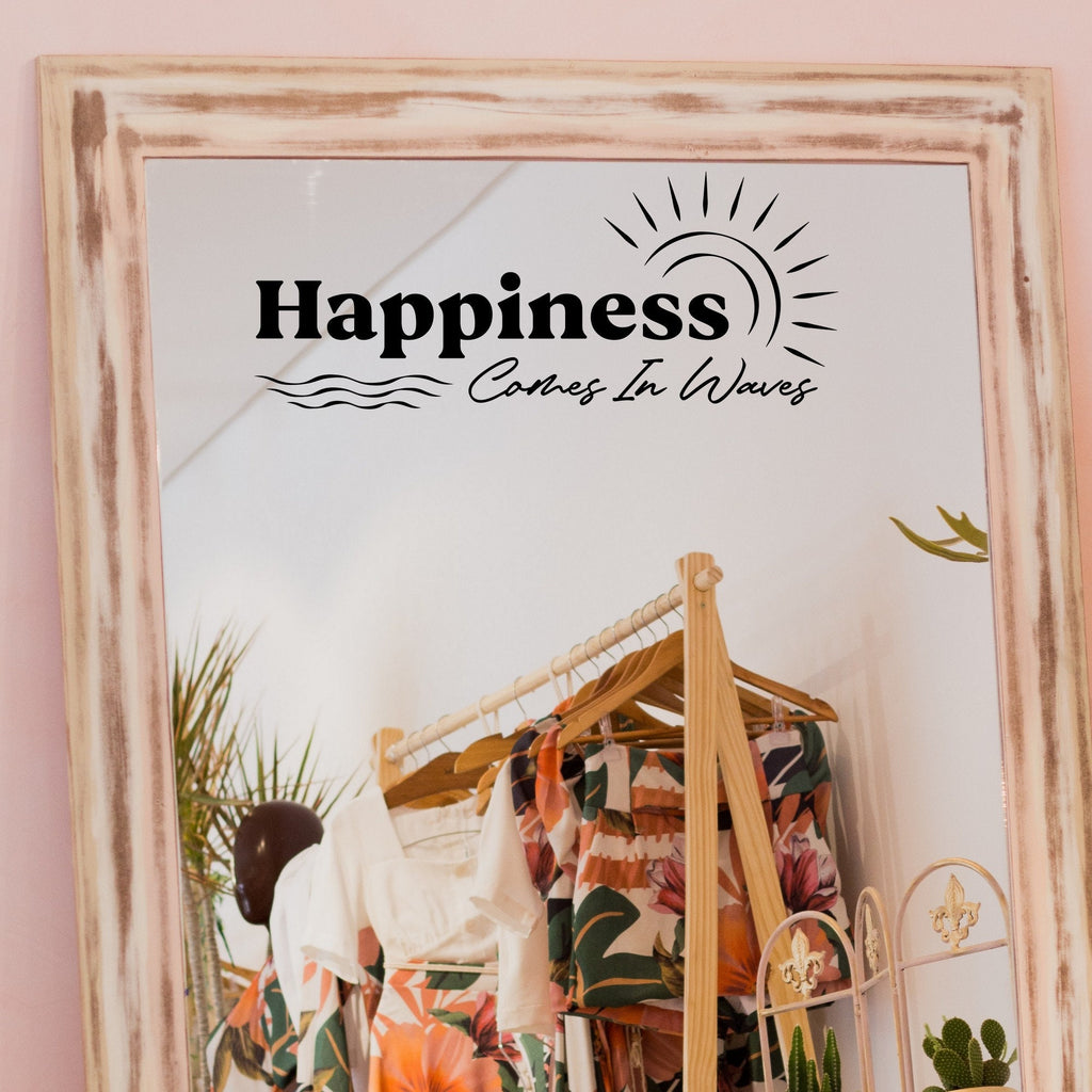 Black “Happiness Comes In Waves” vinyl sticker on a framed dressing-room mirror