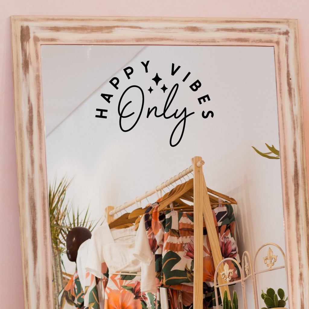 Black “Happy Vibes Only” vinyl sticker on a framed dressing-room mirror
