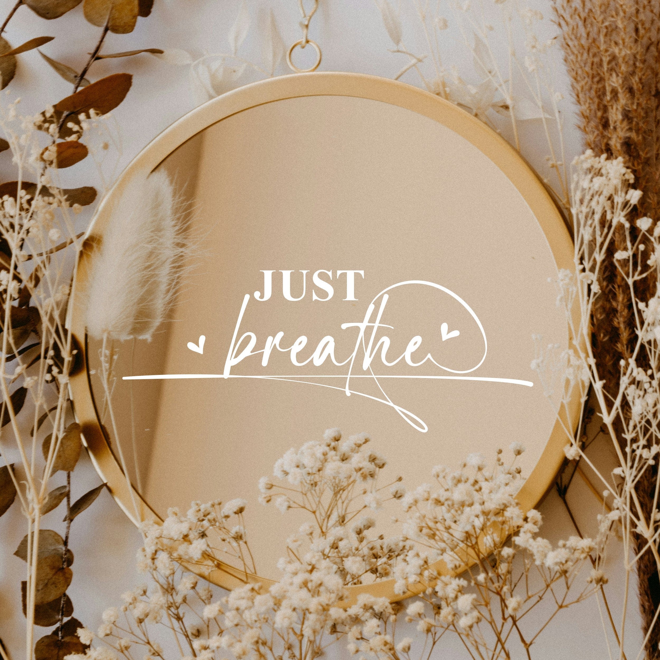 White “Just Breathe” vinyl sticker on a round mirror with dried flowers