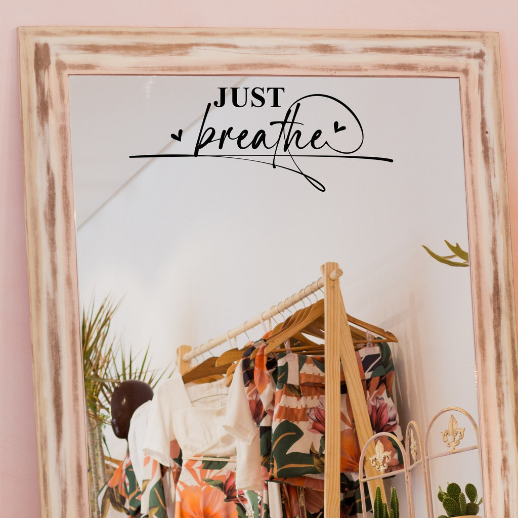 Black “Just Breathe” vinyl sticker on a framed dressing-room mirror