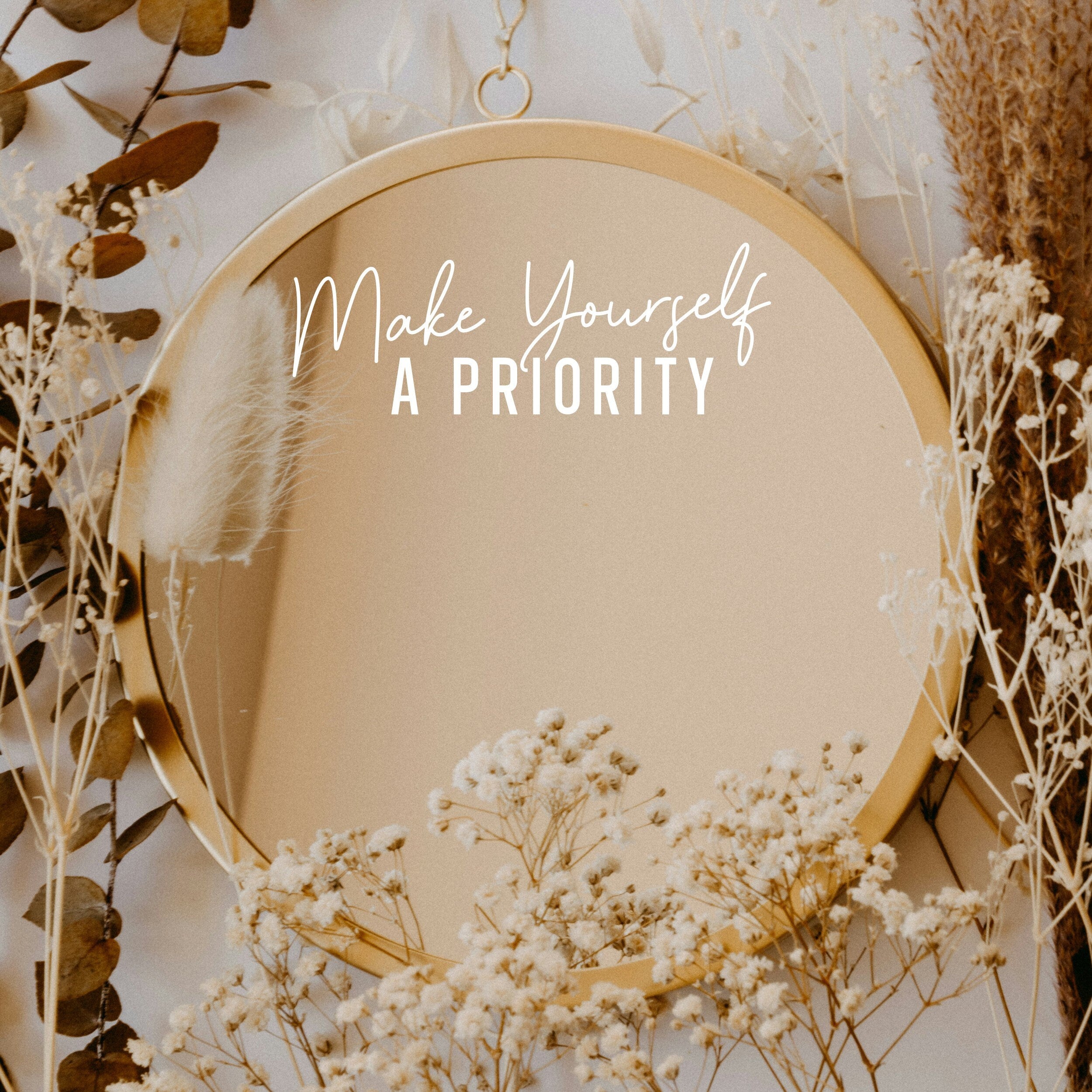 White “Make Yourself A Priority” vinyl sticker on a round mirror with dried flowers