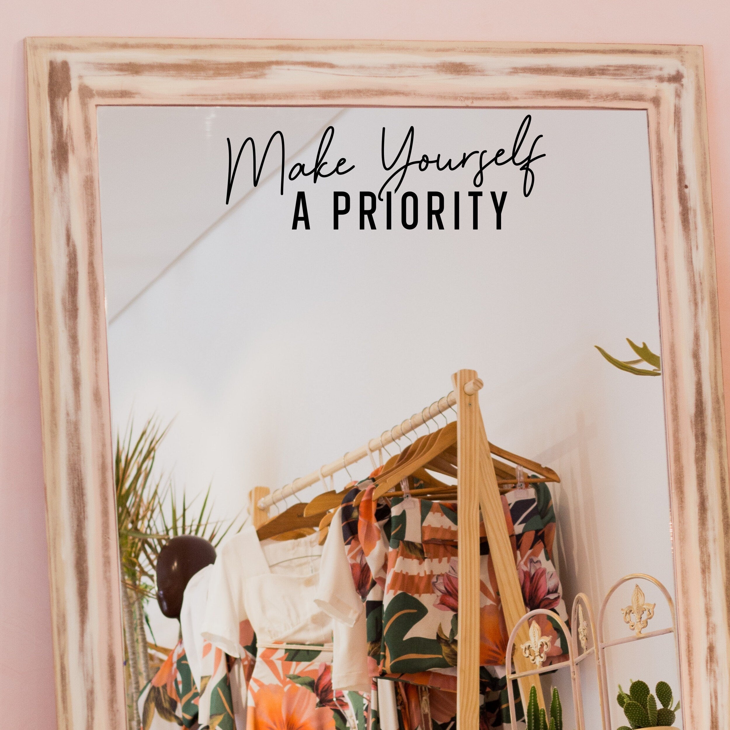 Black “Make Yourself A Priority” vinyl sticker on a framed dressing-room mirror