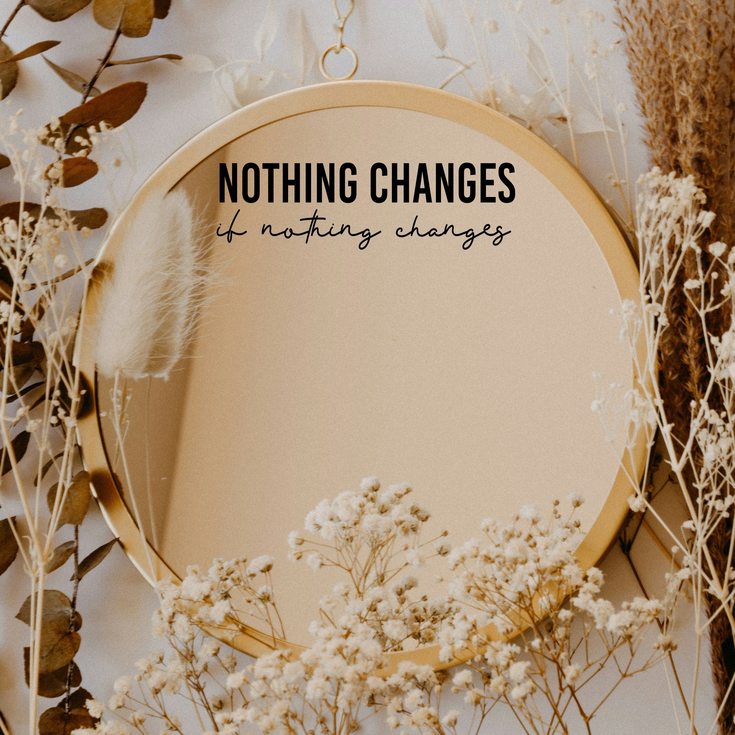 Black “Nothing Changes If Nothing Changes” vinyl sticker on a round mirror with dried flowers