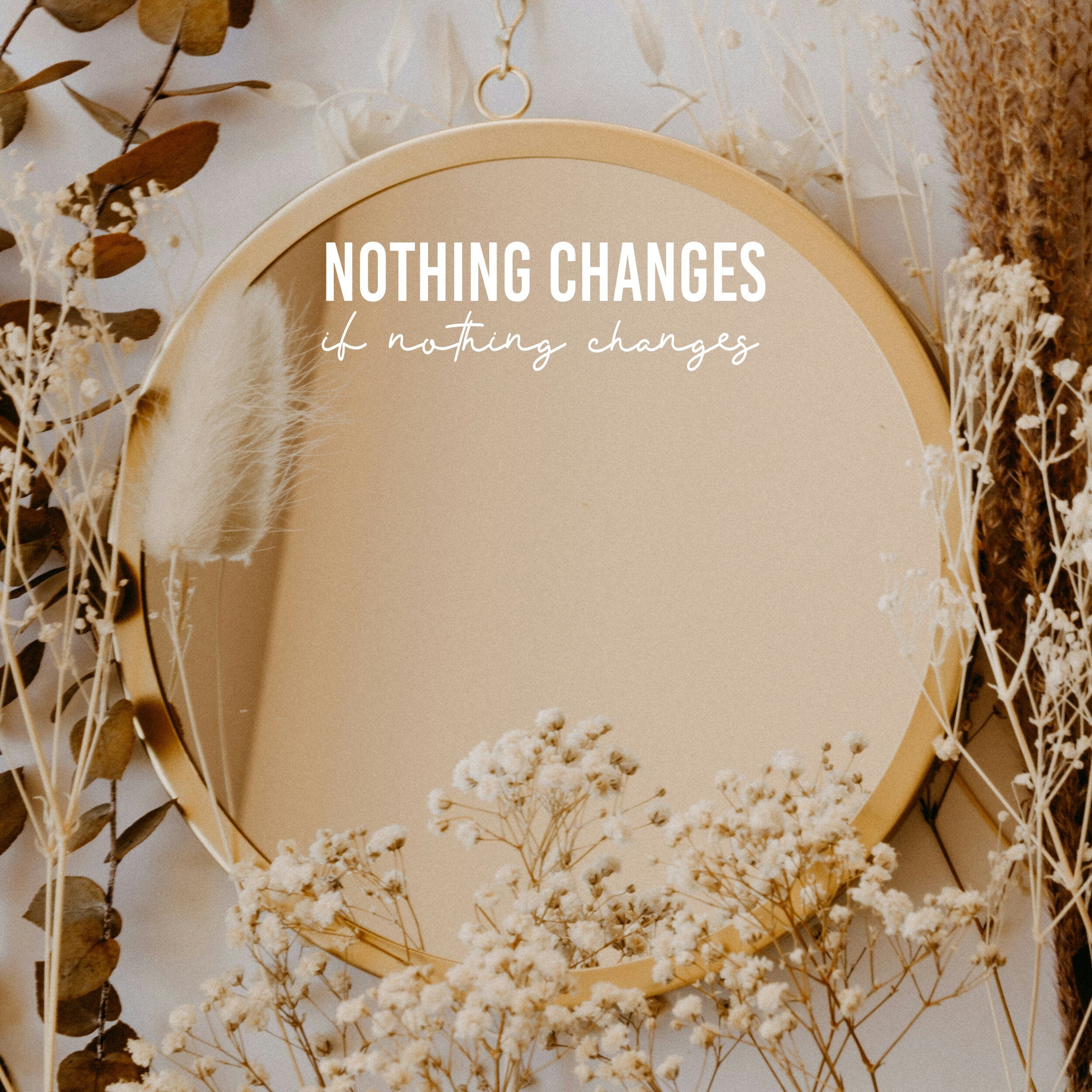 White “Nothing Changes If Nothing Changes” vinyl sticker on a round mirror with dried flowers