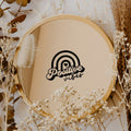 Black “Positive Vibes” vinyl sticker on a round mirror with dried flowers