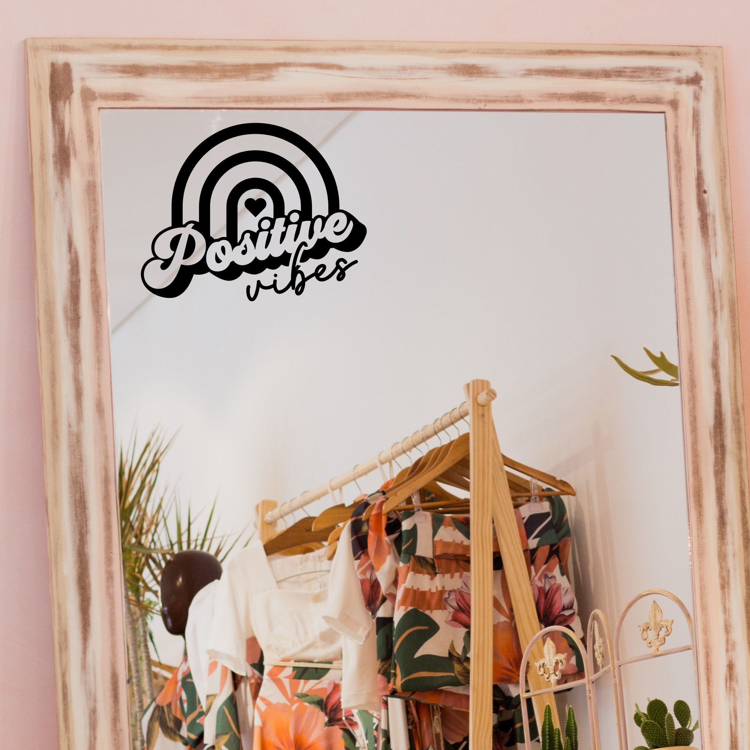 Black “Positive Vibes” vinyl sticker on a framed dressing-room mirror