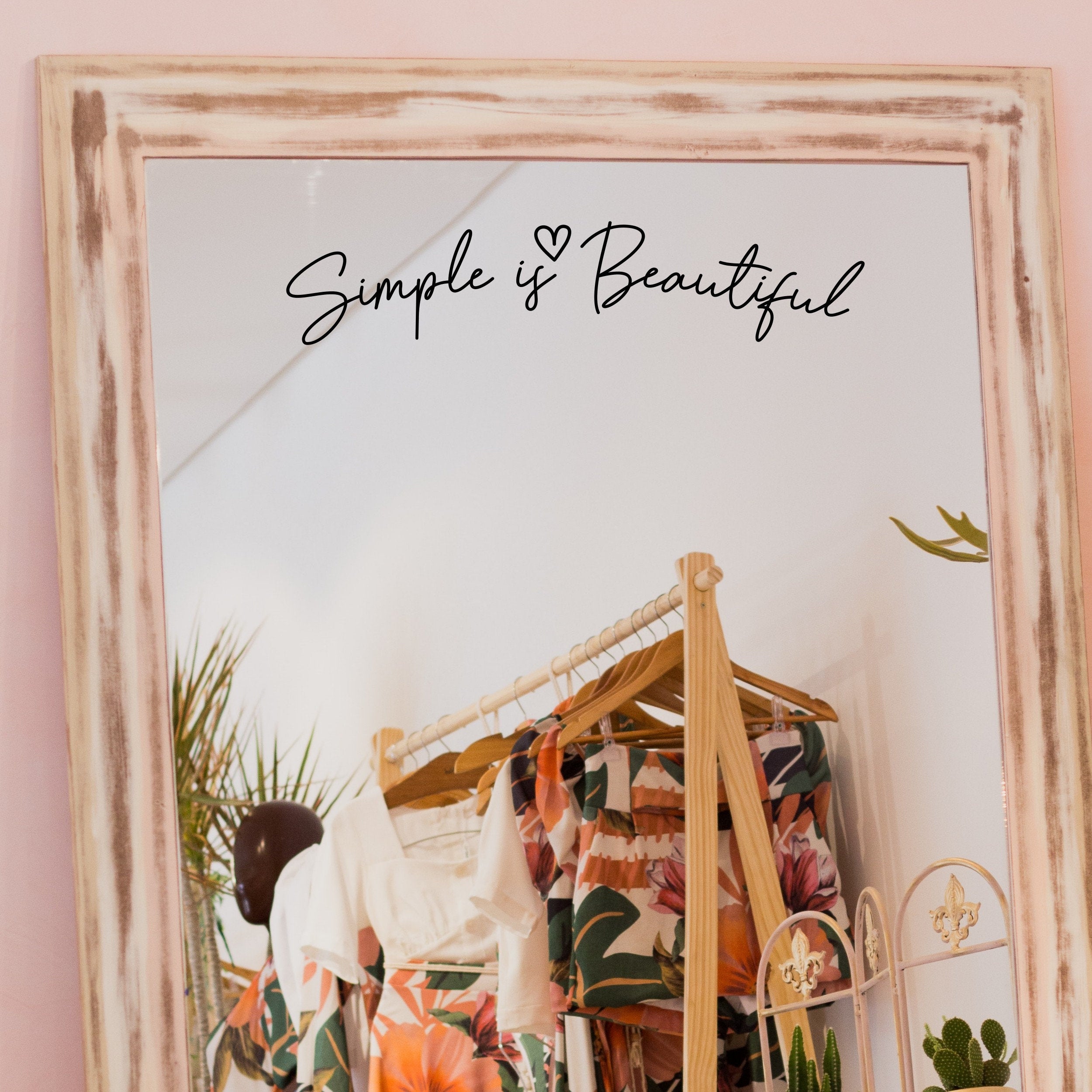 Black “Simple Is Beautiful” vinyl sticker on a framed dressing-room mirror