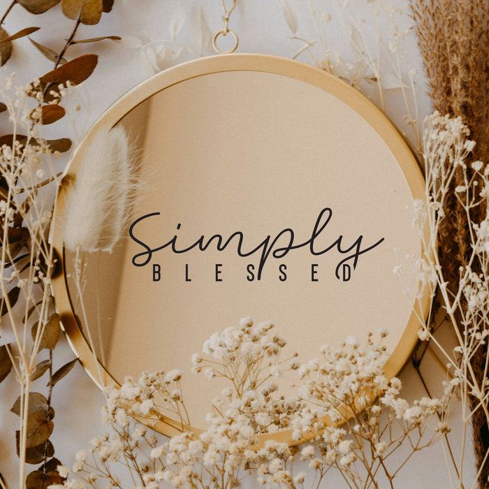 Black “Simply Blessed” vinyl sticker on a round mirror with dried flowers