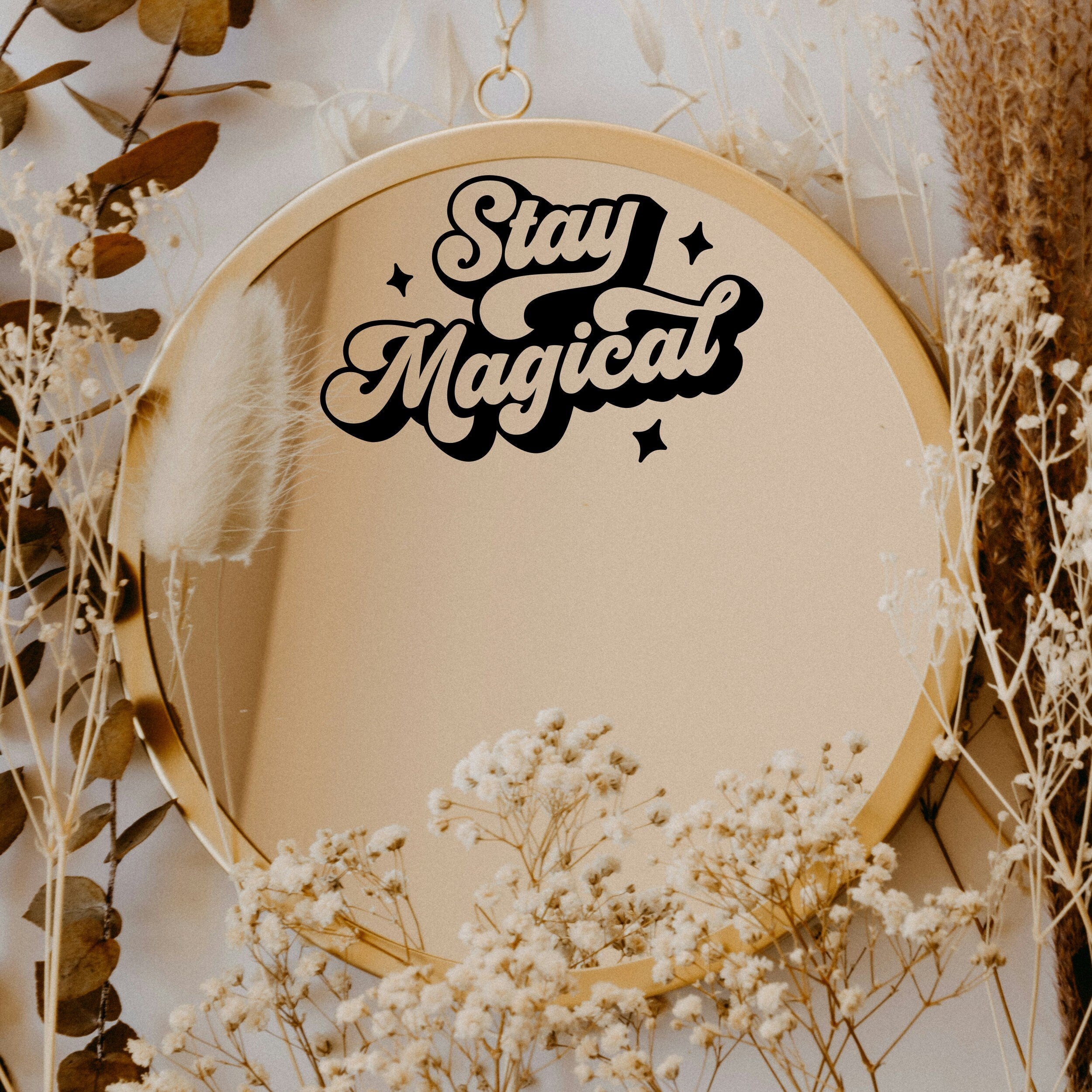 Black “Stay Magical” vinyl sticker on a round mirror with dried flowers