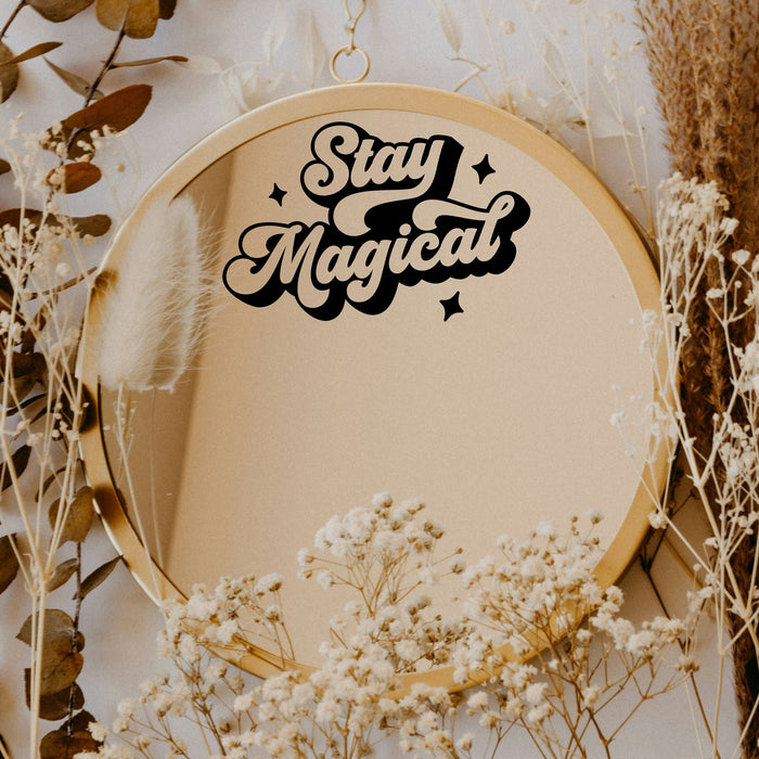Black “Stay Magical” vinyl sticker on a round mirror with dried flowers