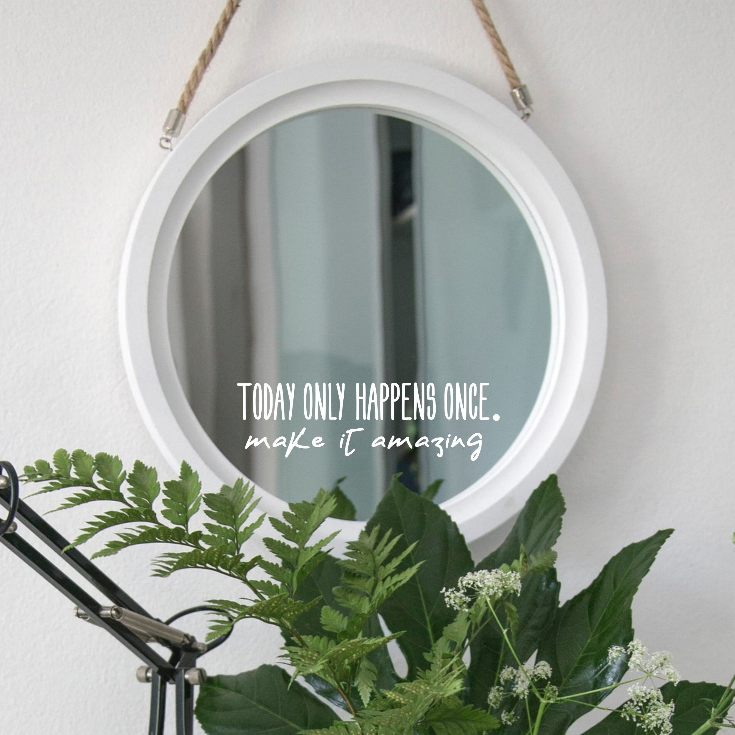 White “Today Only Happens Once, Make It Amazing” mirror decal on a round white-framed mirror with green plants