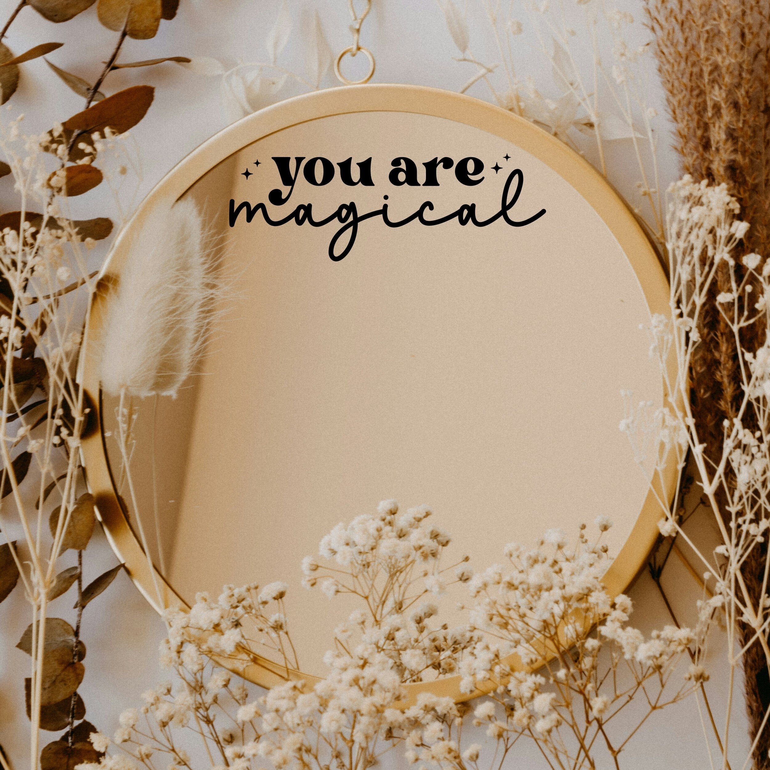 Black “You Are Magical” vinyl sticker on a round mirror with dried flowers