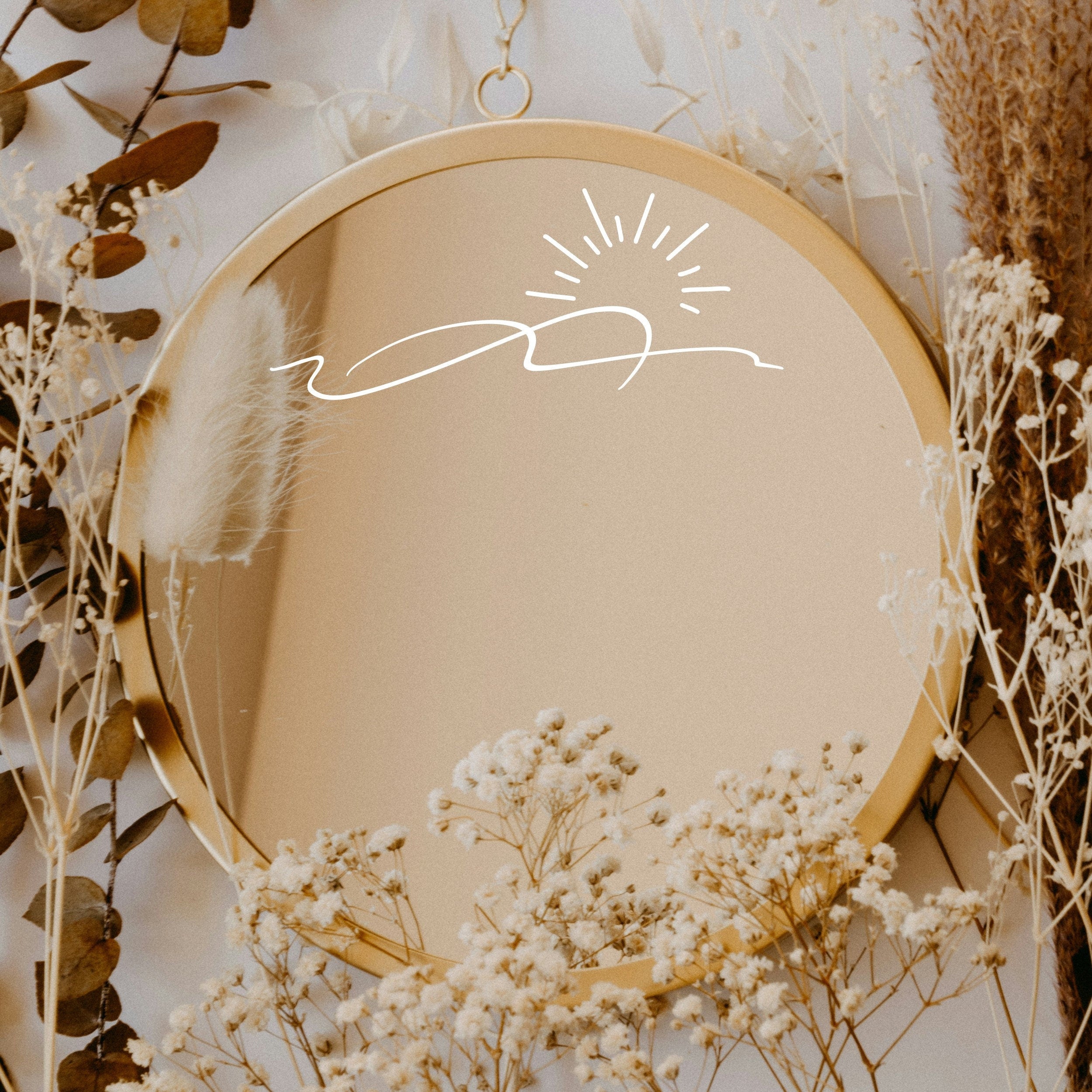 White “Sunrise” vinyl sticker on a round mirror with dried flowers