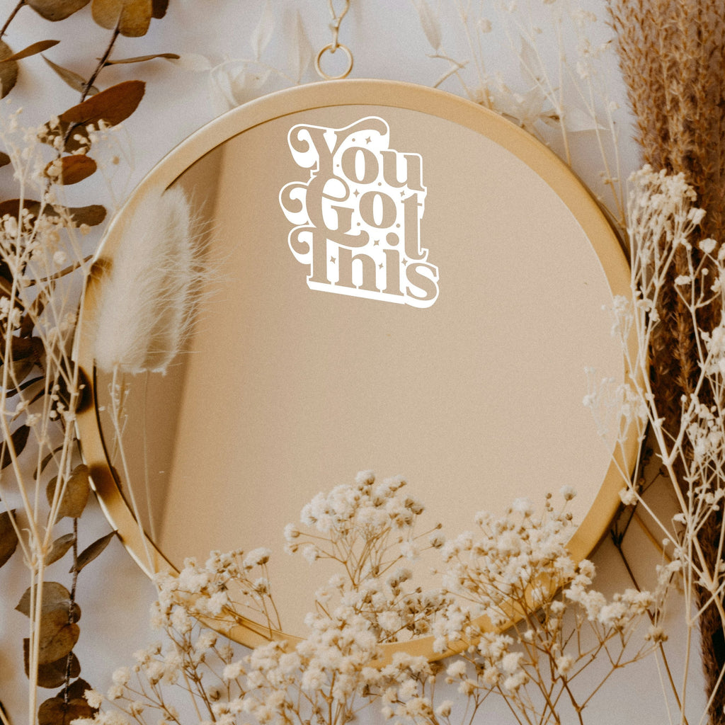 White “You Got This” vinyl sticker on a round mirror with dried flowers