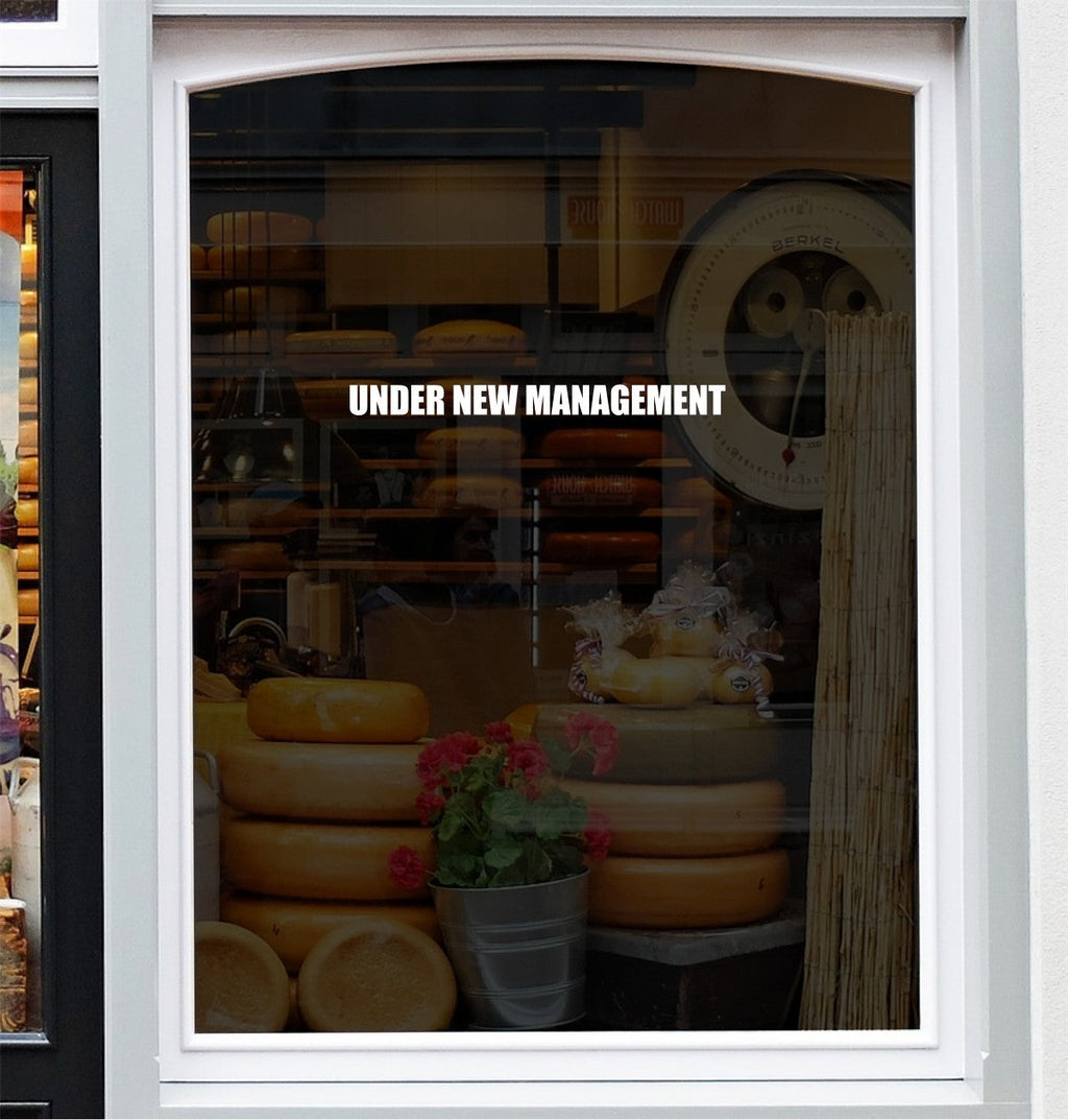 Smaller Under New Management vinyl decal on a shop window