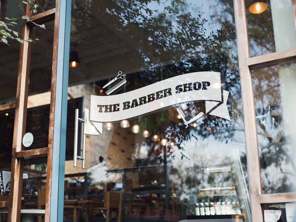 The Barber Shop Banner Window Sticker shown in an alternative retail window setting