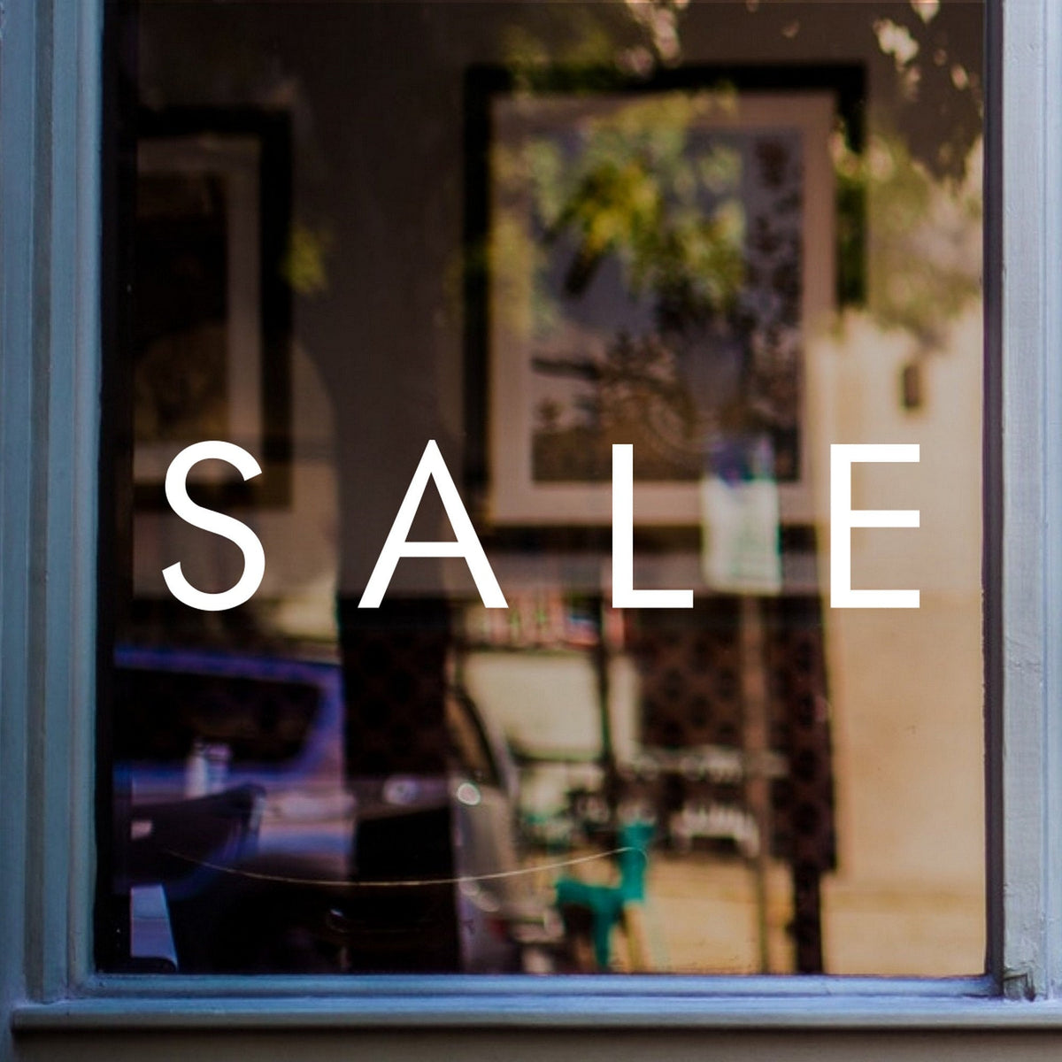 Sale Shop Window Sticker for Retail Displays shown on a blue-framed shop window