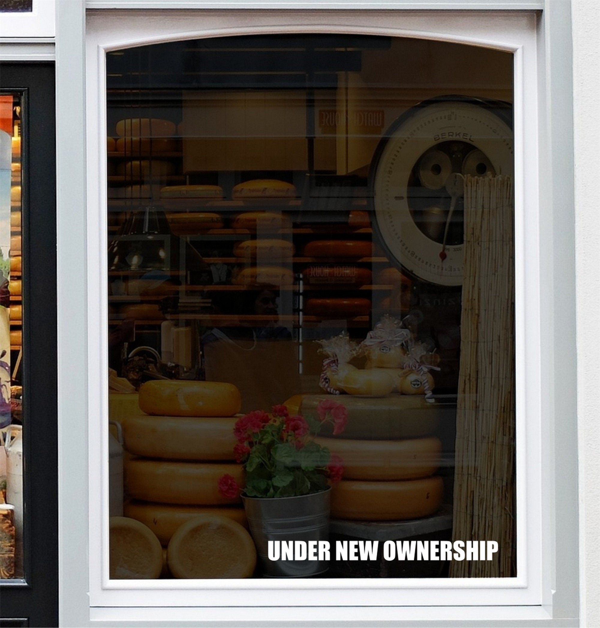 Under New Ownership Shop Window Sticker displayed on a storefront glass pane