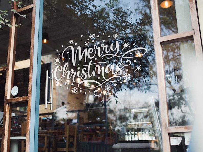 White Merry Christmas snowflake sticker on a frosted shop window