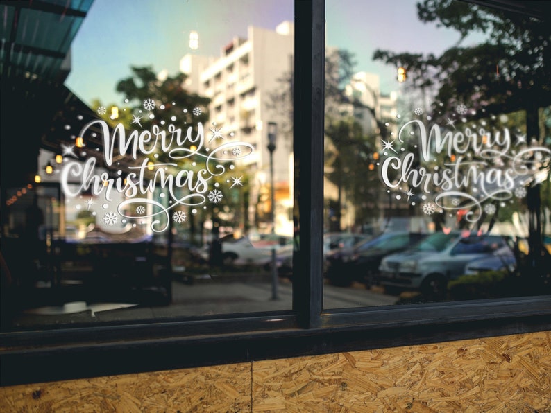 White Merry Christmas snowflake sticker on a large outdoor-facing window