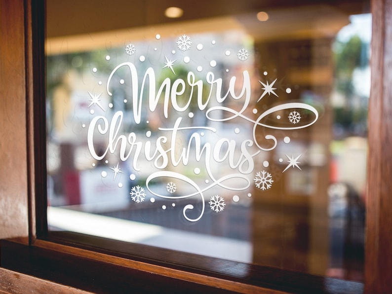 White Merry Christmas snowflake sticker on a festive shop display