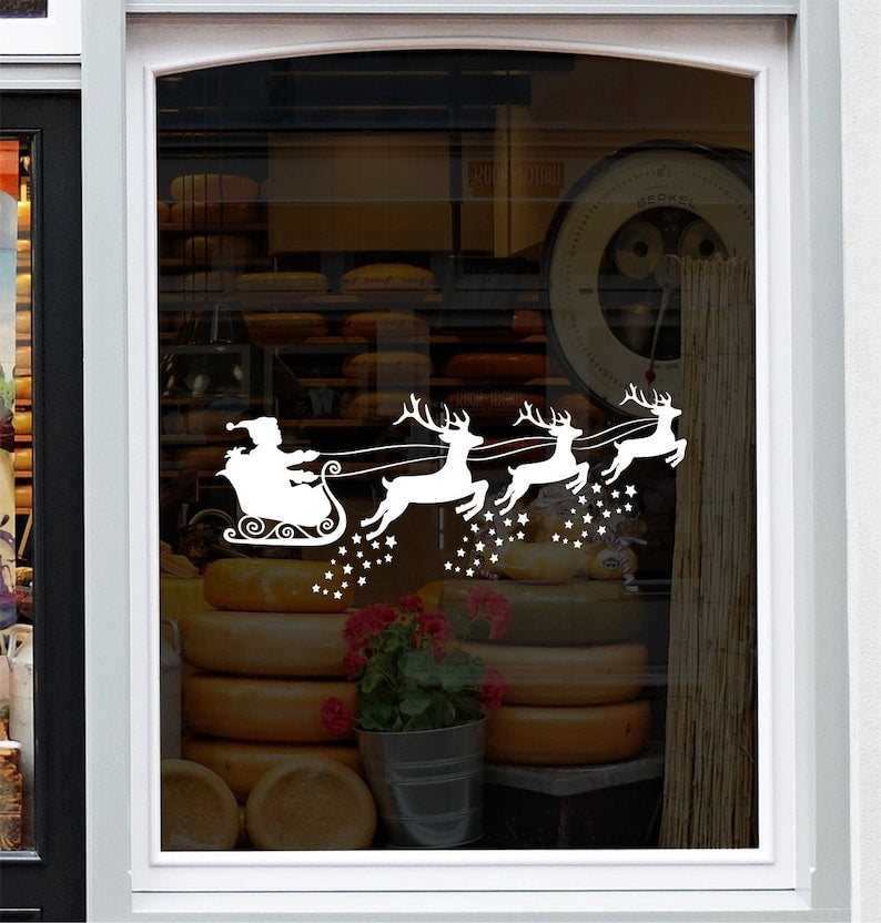 White Santa sleigh and reindeer Christmas sticker on a grey shop window