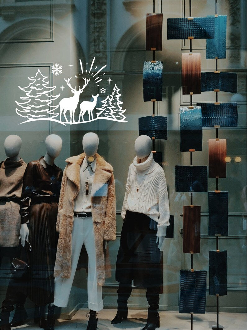 White reindeer and pine tree Christmas window sticker on a retail display
