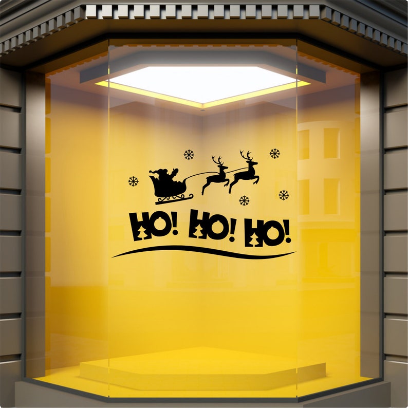 HO HO HO Santa sleigh Christmas decal displayed on a yellow shop window