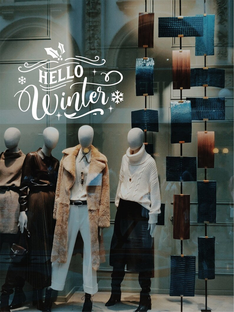 White Hello Winter Christmas decal on a festive retail window display