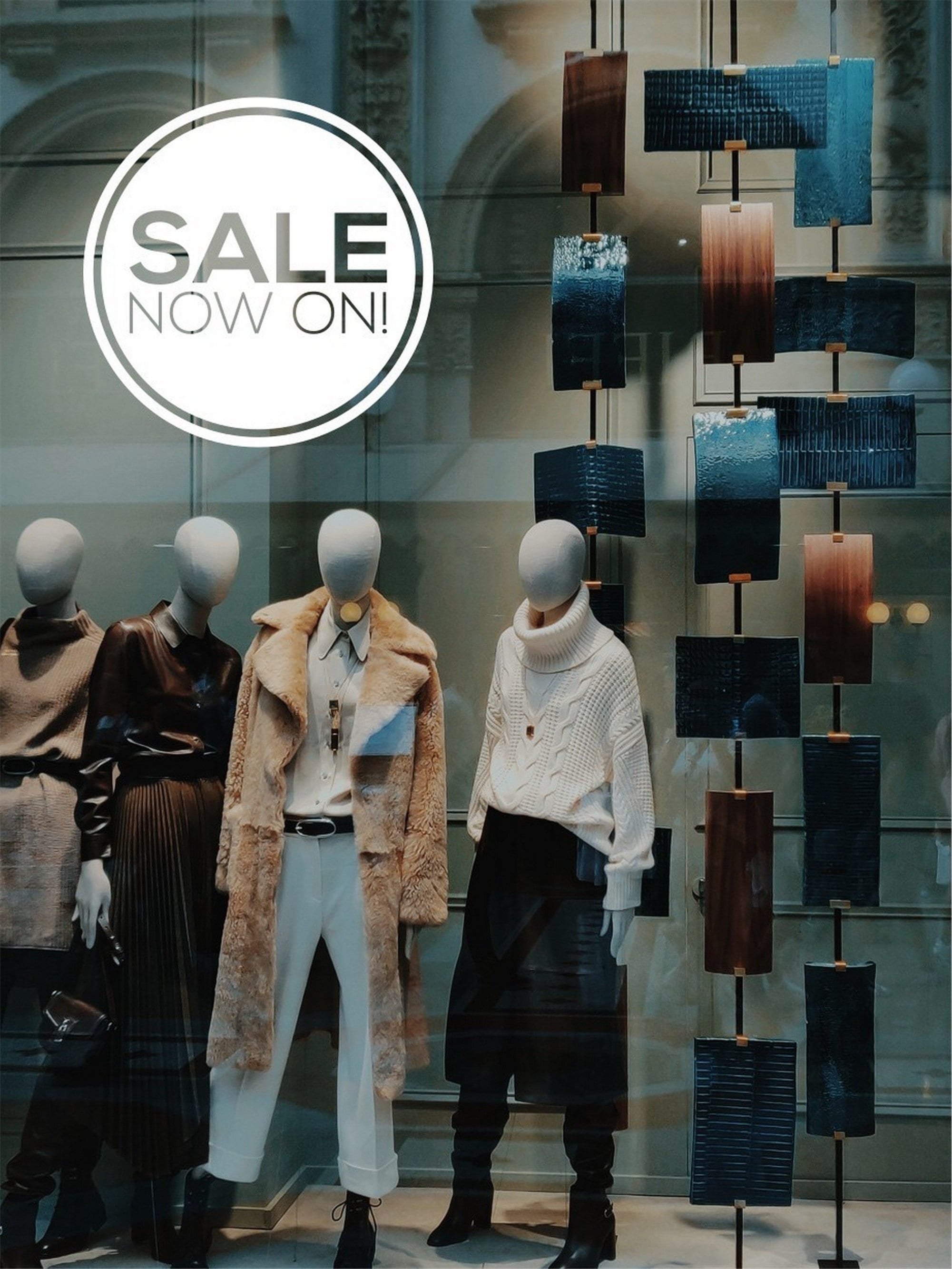 Sale Now On Shop Window Sticker shown in an alternative retail window setting