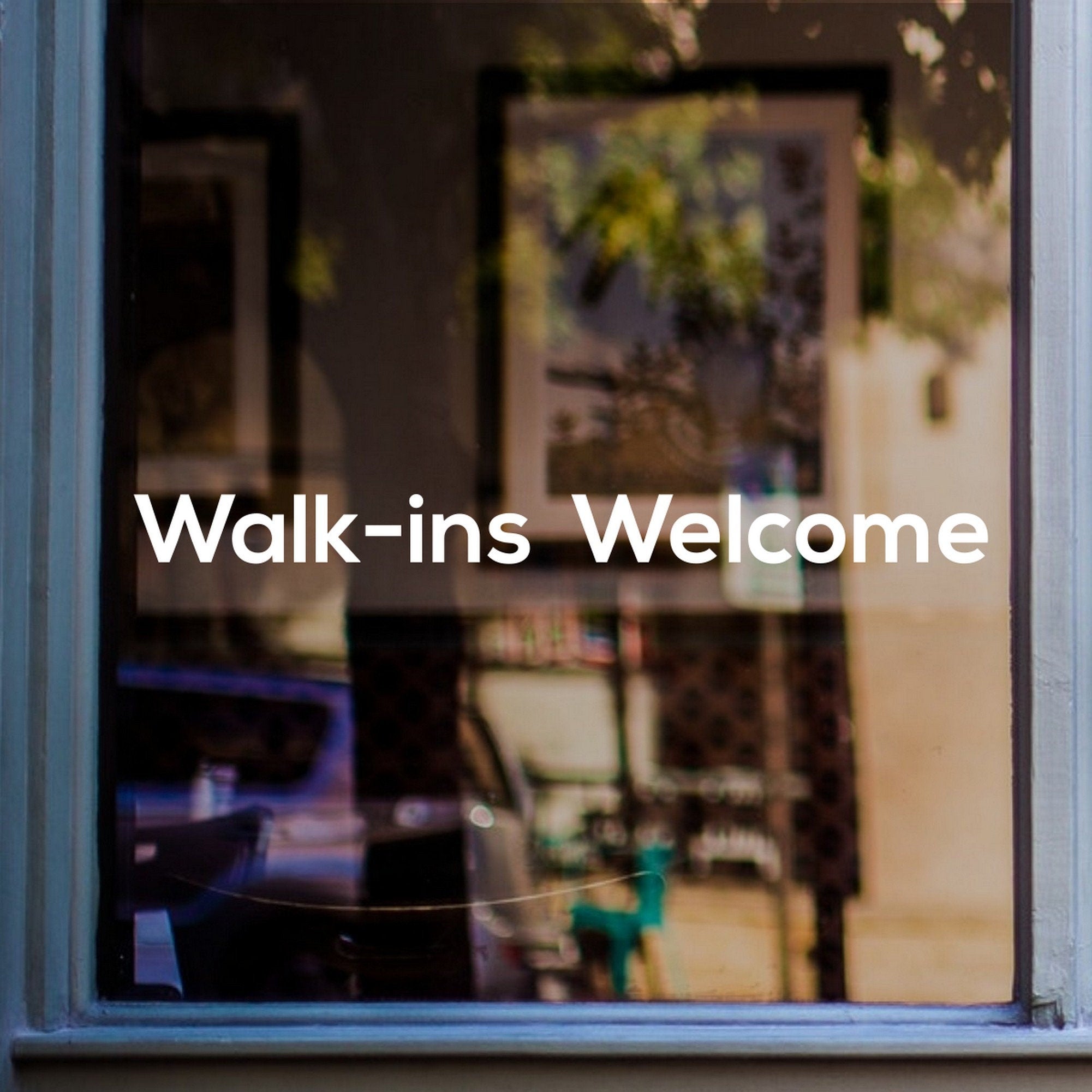 Walk-Ins Welcome Window Sticker for Salons & Barbers shown on a blue-framed shop window