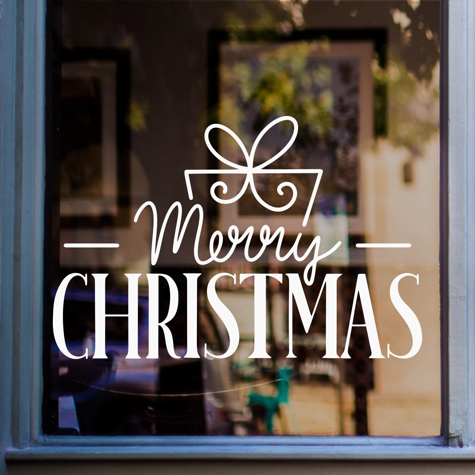 Merry Christmas window decal featuring elegant festive lettering with a decorative ribbon bow in white vinyl