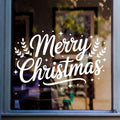 Merry Christmas window sticker with festive foliage and stars displayed in white vinyl on a window.