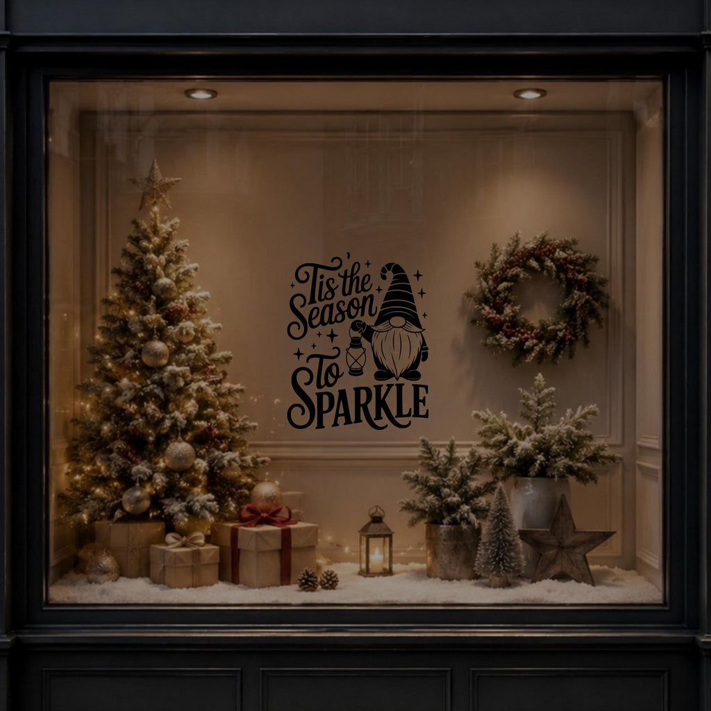 Tis the Season to Sparkle gnome vinyl decal displayed on a dark window with Christmas decorations behind.